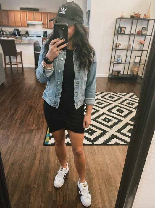 A reviewer wearing the dress paired with a denim jacket, a baseball cap, and white sneakers