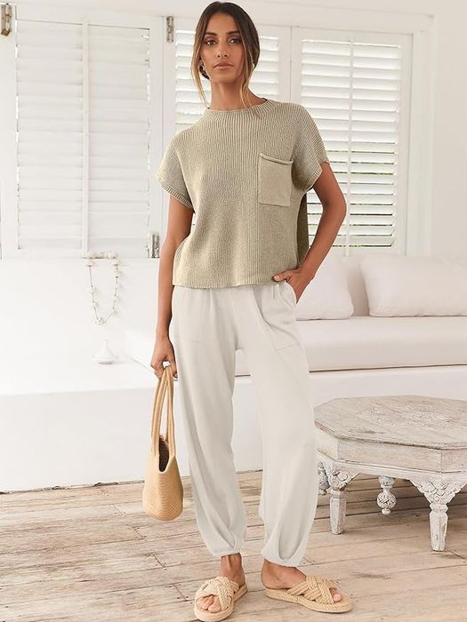 A person in a casual cream knit top paired with loose white trousers