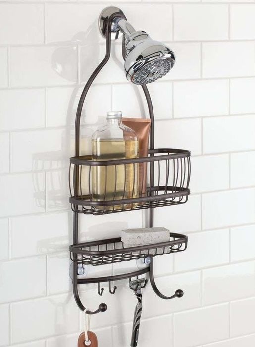 A shower caddy hanging in the shower, holding soap and shampoo bottles.