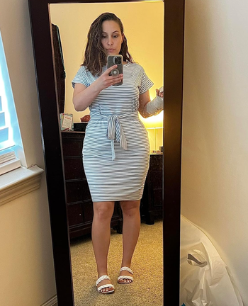 reviewer showing off the black and white striped version of the dress