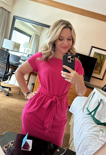 reviewer modeling a hot pink tie-waisted midi T-shirt dress