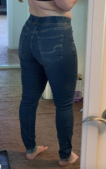 A reviewer showing the backside of the jeans
