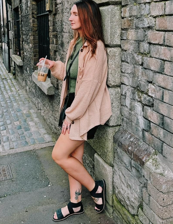 A reviewer sporting a beige oversized waffle weave button-up long-sleeve shirt