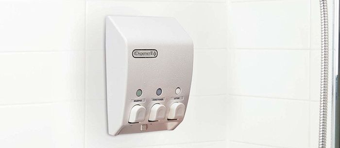 The shower dispenser is hanging on a shower wall.