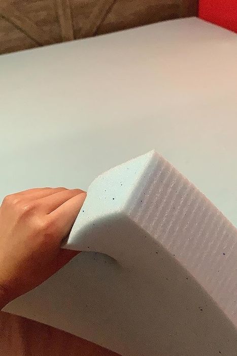 Hand squeezing the thick mattress topper