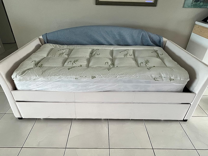 The reviewer's image of the mattress topper placed on the couch again