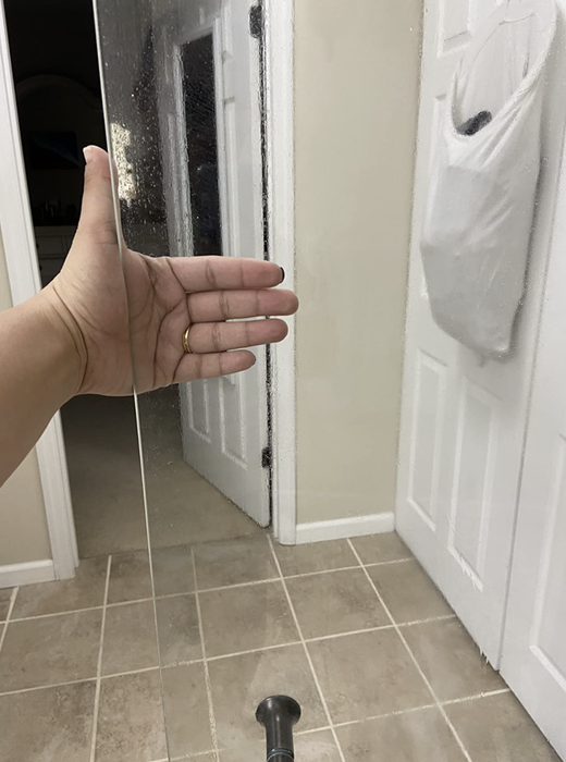 The same shower door is now spotless and clear, free of any fog or stains.