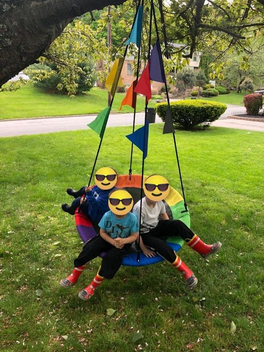 A reviewer’s image showing three kids swinging on the saucer swing.