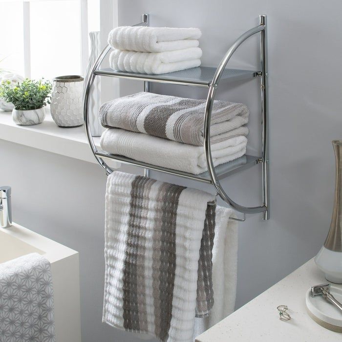 A modern bathroom shelf unit showcasing neatly folded gray and white towels, a washcloth, and decorative accents placed nearby.