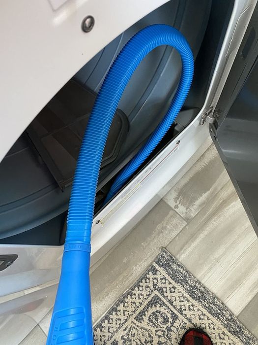 A reviewer’s image of the vacuum hose attachment being used on a dryer