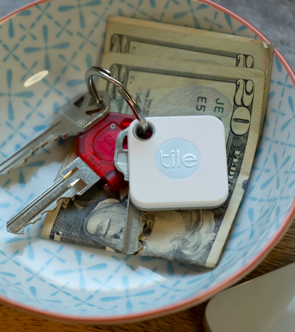 A trinket dish featuring a Tile attached to a set of keys.