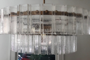 The same chandelier after applying the cleaning spray, now gleaming with clear, bright panels instead of the former haze