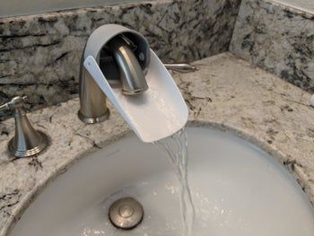 The faucet extender attached to a running faucet