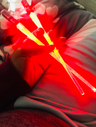 A reviewer holding chopsticks that are glowing red, a unique and captivating sight.