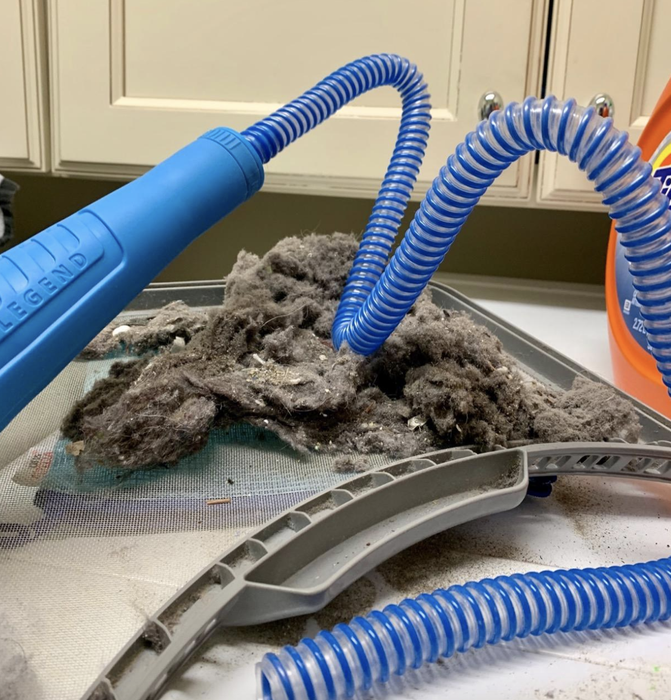 A reviewer’s photo showing the blue vacuum attachment covered in dust