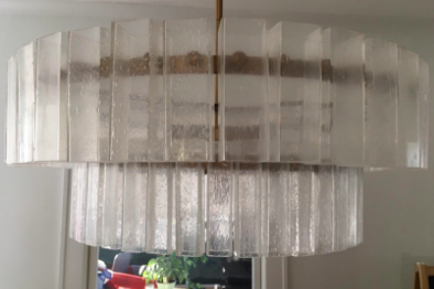 A reviewer image featuring a modern chandelier with large, hazy glass panels