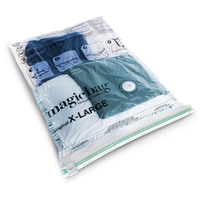 A vacuum-sealed MagicBag storage bag holding neatly folded clothes, with the text 'magicbag Original X-LARGE' clearly displayed on the bag.