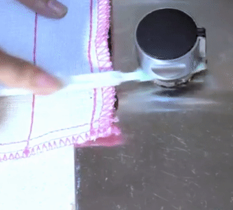 A hand using one of the detailing brushes to scrub a stove burner clean