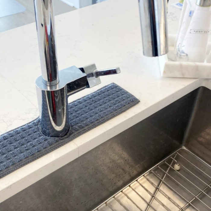 A drip catcher positioned around the faucet of a kitchen sink to prevent splashes and spills.