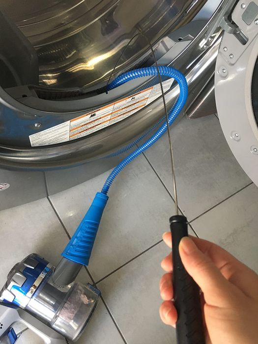 Reviewer using the blue dryer vent cleaning attachment with their vacuum to clean out their vent