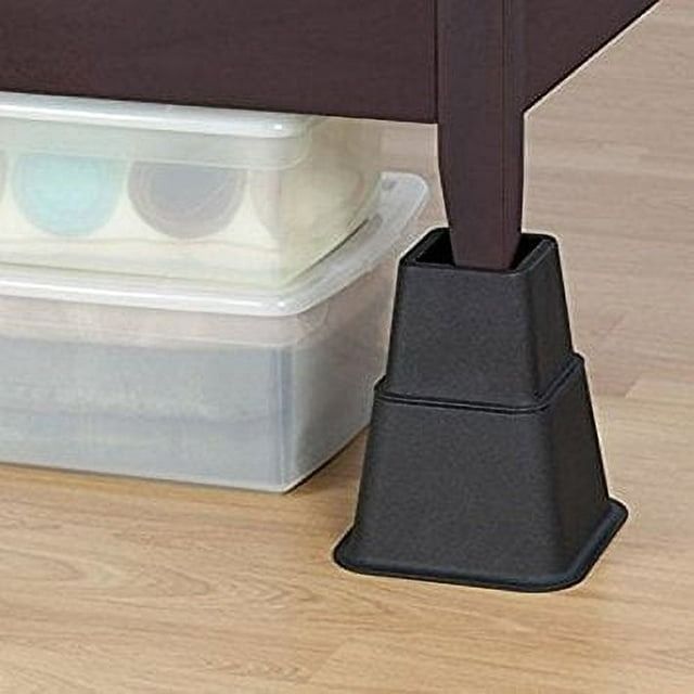 A close-up view of a furniture leg raised on a black riser, with storage boxes neatly placed beneath the bed frame, highlighting an efficient and space-saving organization solution in a home environment.