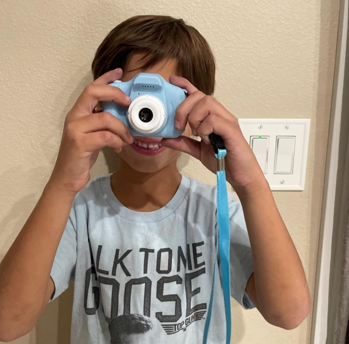 A child using a small blue camera.