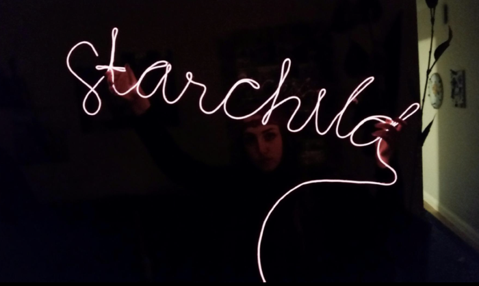 A reviewer using the cord to form the word 'starchild' in neon lights.