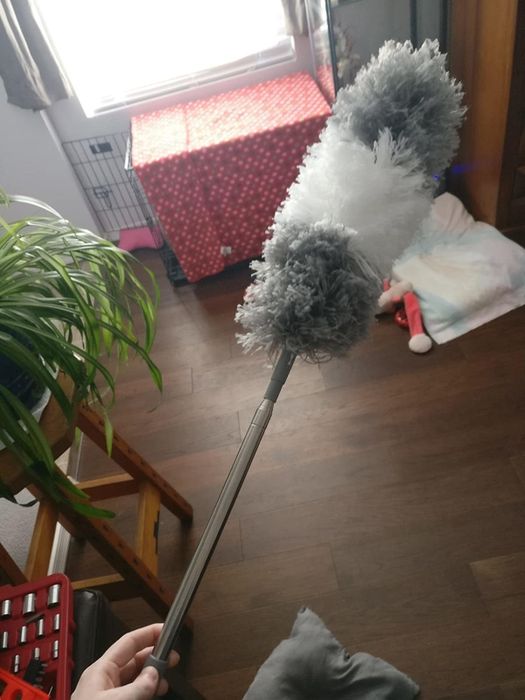 An Amazon reviewer holding the extendable duster in hand