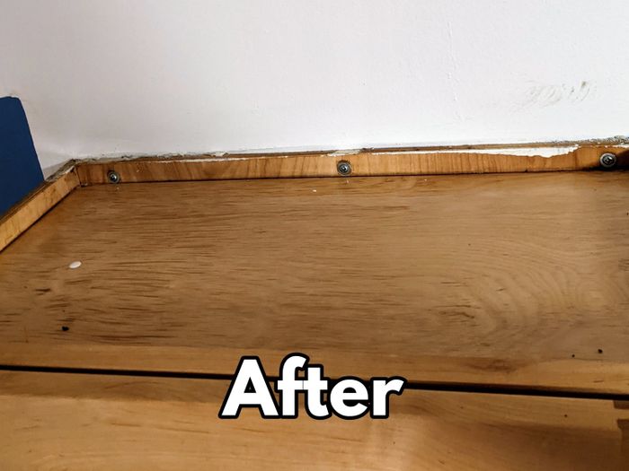The top of the same wood cabinet, now sparkling clean after using the scour paste