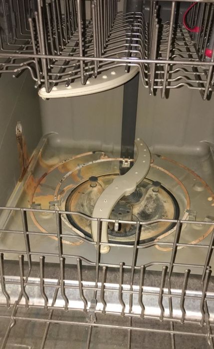 A reviewer's dishwasher covered in brown stains at the bottom