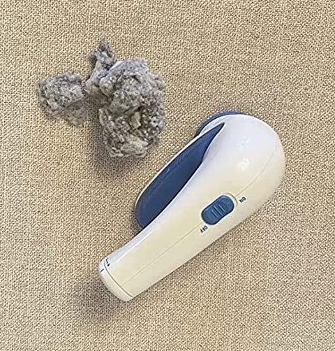 A reviewer’s image of the fabric shaver next to a pile of lint it removed from the couch