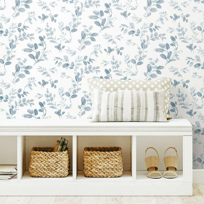 the white wallpaper adorned with blue leaves in a room