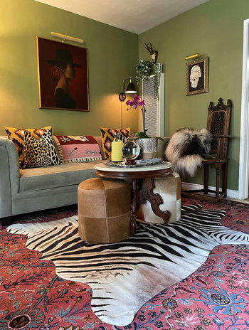 A faux hide rug placed over a Turkish rug in the reviewer's vibrant, maximalist living room.