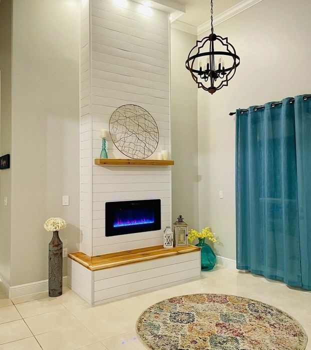 Reviewer's faux fireplace mounted on the wall in the living room