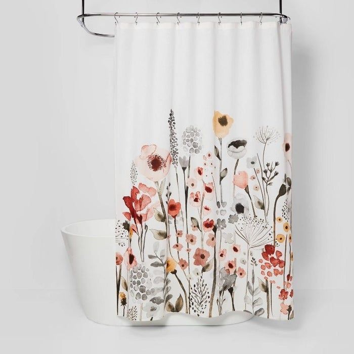 floral shower curtain draped over a bathtub