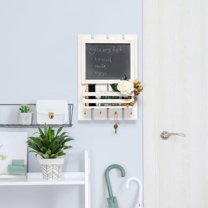 A wall-mounted organizer with a chalkboard listing 'bread, milk, eggs,' a white wallet, a plant, and an umbrella neatly arranged in an entryway setup