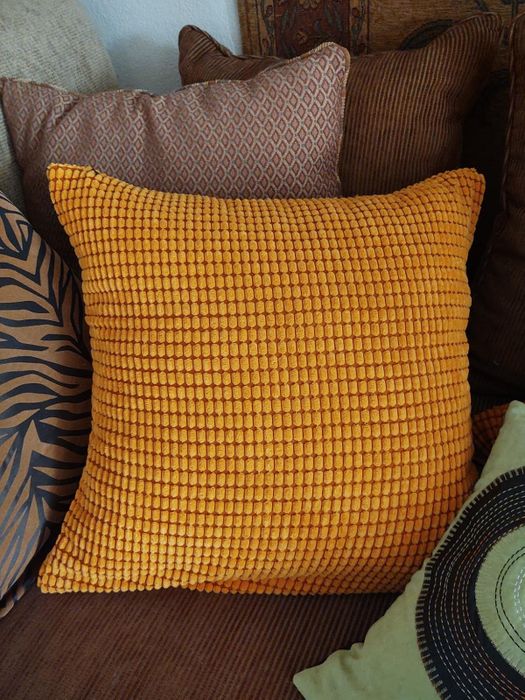 A collection of textured throw pillows resting on a couch.
