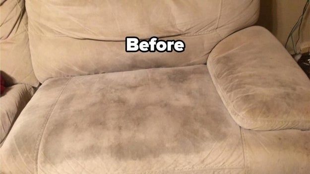 A reviewer's photo displaying a tan couch with a dark stain on the seat and accompanying text.