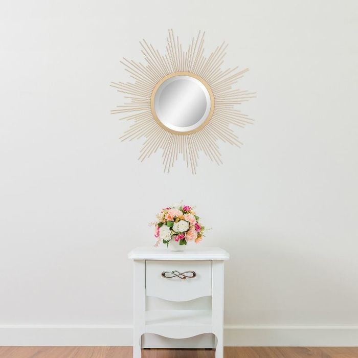 sunburst mirror placed above a side table