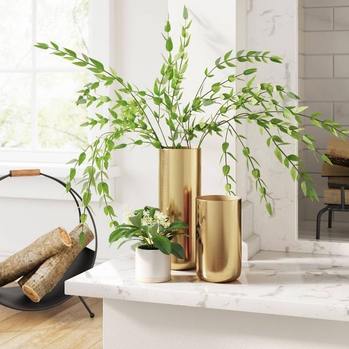 Gold vases with plants on a kitchen counter