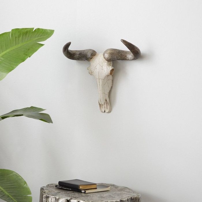 A cow skull mounted on the wall, adding a bold and rustic touch to any space.
