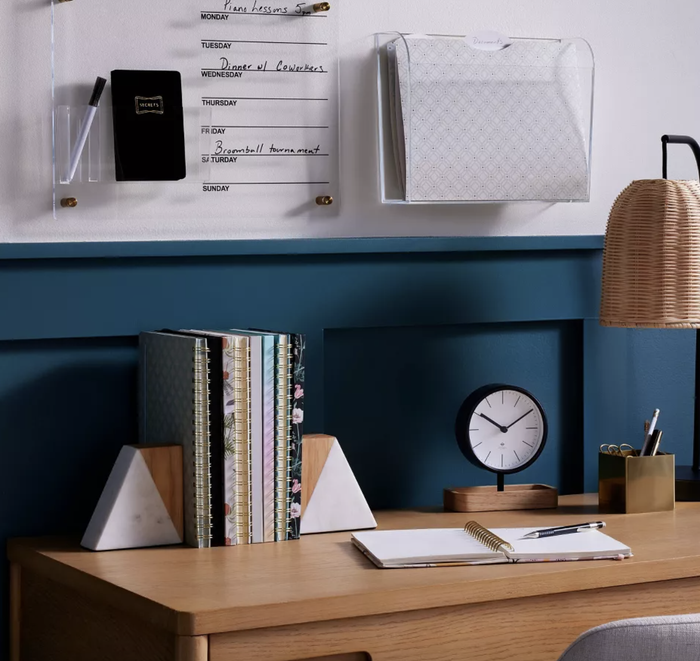 bookends holding a stack of books neatly arranged on a desk