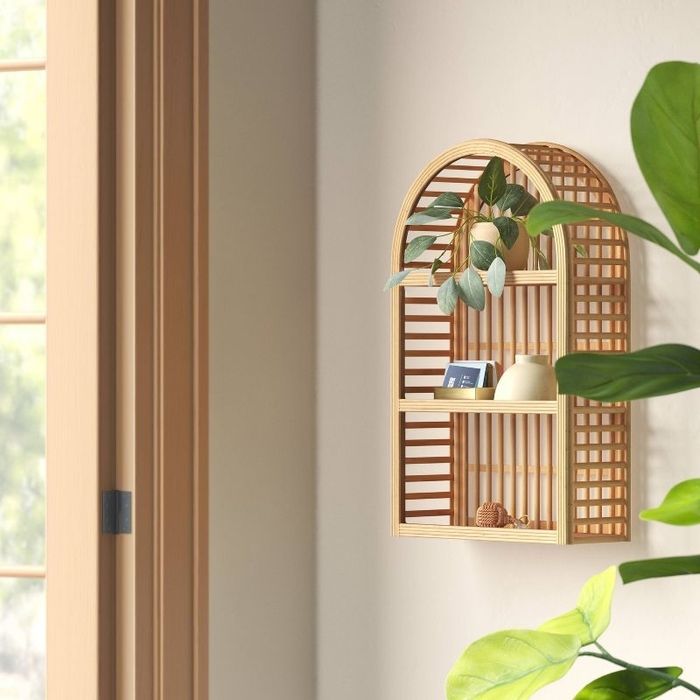 The wall shelf holding a variety of decorative pieces