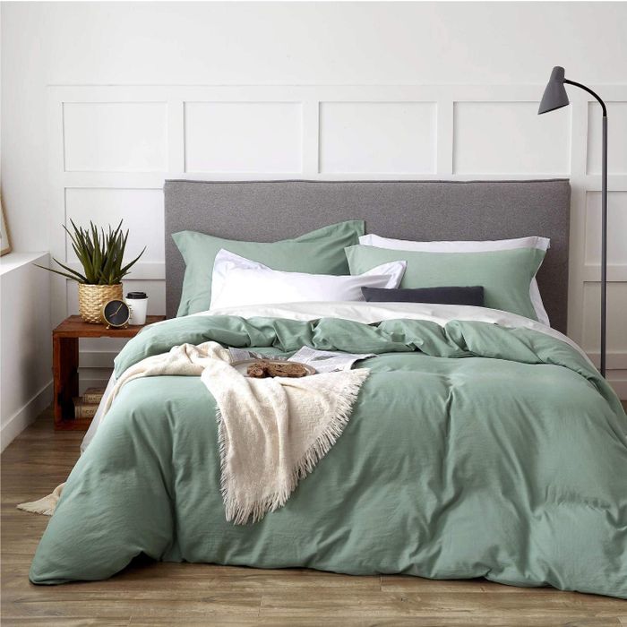 A serene sage green duvet resting on a bed.