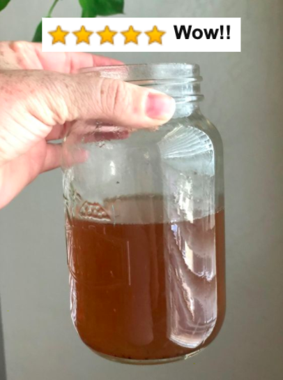 Reviewer holding a cup filled with dirty Keurig water with the caption from Amazon saying 