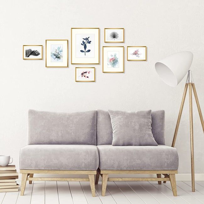 The frames hanging on a wall behind a sofa