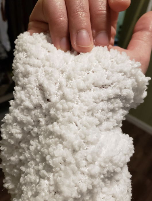 close-up shot of the sleeve of a white sweater worn by the reviewer