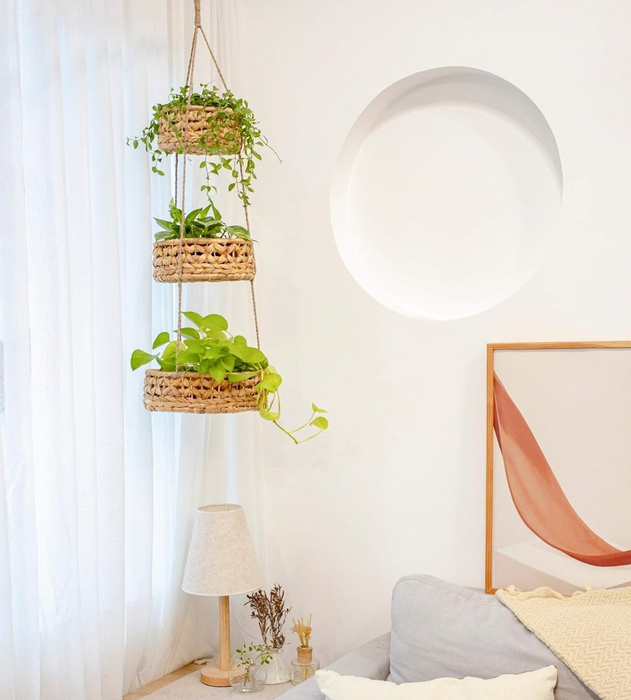 Hanging indoor plants arranged in a three-tier woven basket