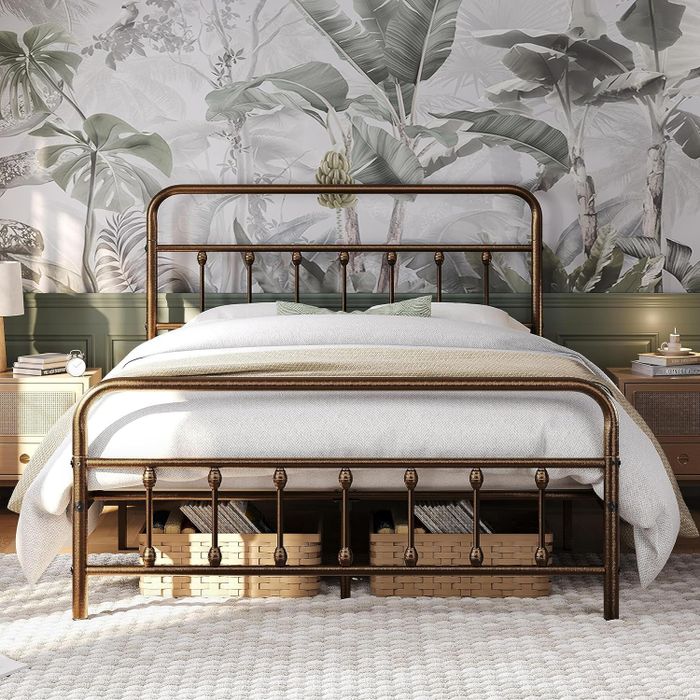 A stylish bedroom featuring a bronze metal-frame bed, crisp white bedding, wooden nightstands, and a large tropical-themed wall mural
