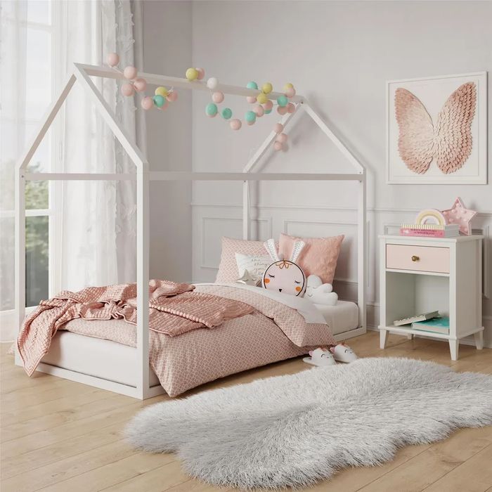 The bed in white, set in a child's room.